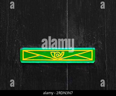 Farbenfroher Briefkastenschlitz mit altem Holzhintergrund. Stockfoto