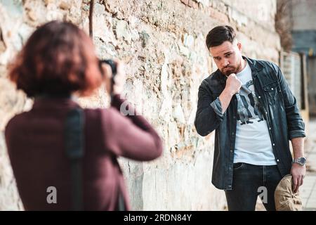 Fotograf, der Fotos von einem jungen bärtigen Mann macht Stockfoto