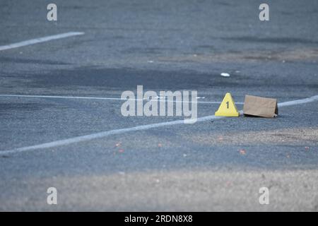 Newark, Usa. 22. Juli 2023. Beweismarkierungen am Tatort in Newark. Die Behörden untersuchen eine Schießerei auf einem Parkplatz außerhalb des Nachtclubs Marbella Lounge am Broadway in Newark. Die Schießerei geschah gegen 3:15 UHR am Samstagmorgen. Ein Mann wurde von der Staatsanwaltschaft von Essex als tot bestätigt. Es gibt keine Informationen darüber, ob Verdächtige gefasst wurden. Die Staatsanwaltschaft von Essex untersucht die Schießerei. Kredit: SOPA Images Limited/Alamy Live News Stockfoto