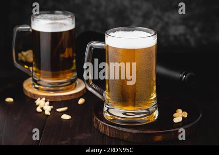 Becher mit Bier und salzigen Nüssen. oktoberfest-Atmosphäre, Hintergrund der Craft-Brauerei Stockfoto