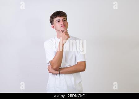 Junger weißer Mann auf isoliertem weißem Hintergrund, der fröhlich mit dem Zeigefinger wegsieht. Stockfoto