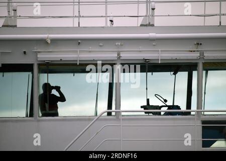 WELLINGTON, NEUSEELAND, 19. MAI 2023: Ein Offizier auf der Brücke der Interislander-Fähre Atarere scannt das Wasser vor uns, während das Schiff auf Picton i zusteuert Stockfoto
