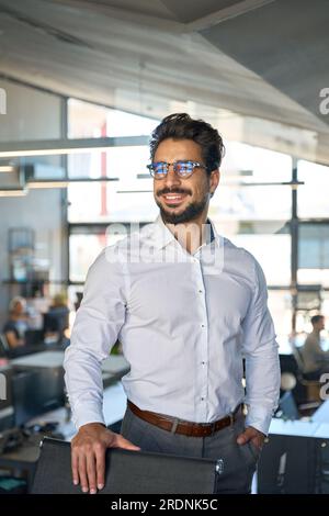 Ein zuversichtlicher junger Geschäftsmann aus Lateinamerika, der eine Brille trägt und wegsieht. Stockfoto