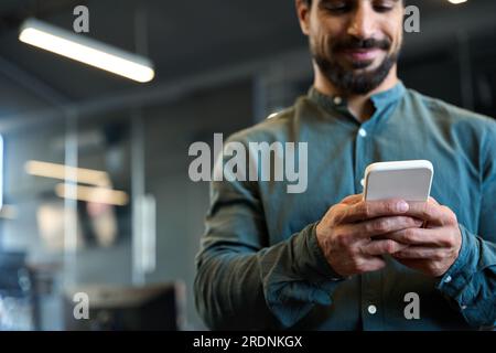 Junger Geschäftsmann, der ein Smartphone mit einem Mobiltelefon in der Hand hält. Nahaufnahme Stockfoto