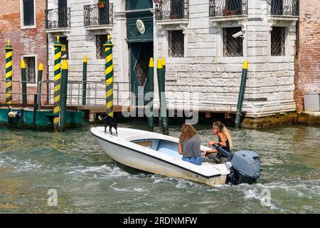 Zwei Frauen und ihr Hund auf einem Boot vor dem Palazzo Civran, Hauptquartier der venezianischen Finanzpolizei, am Canale Grande, Venedig, Italien Stockfoto