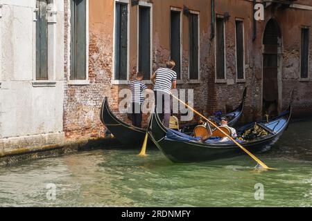 Zwei Gondeln mit Touristen auf dem Rio del Fondaco dei Tedeschi, nicht weit von der Rialtobrücke entfernt, im Sommer Venedig, Venetien, Italien Stockfoto