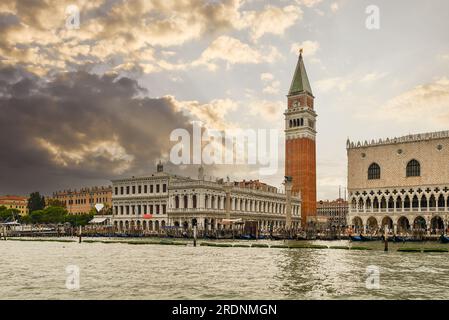 Markusplatz aus dem Markusbecken mit der Marciana-Bibliothek (links), dem Campanile und dem Dogenpalast bei Sonnenuntergang, Venedig, Veneto, Italien Stockfoto