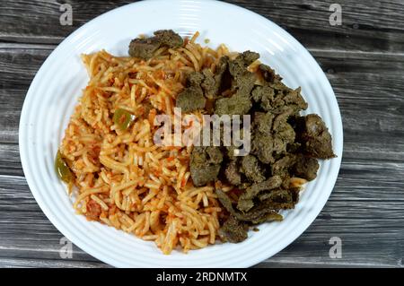 Klassische Spaghetti-Nudelmakkaroni mit Tomatensoße, Knoblauch, Zwiebeln, Gewürzen, Öl und schwarzem Pfeffer, Spaghetti ist eine lange, dünne, feste, zylindrische Pasta A. Stockfoto