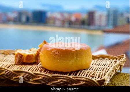 Spanischer hart geräucherter Kuhkäse aus Pria, Asturien, serviert im Freien mit Blick auf den Strand San Lorenzo und die Promenade in Gijon Stockfoto