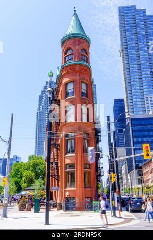 Toronto, Kanada - 19. Juli 2023: Fassade des Gooderham-Gebäudes. Das denkmalgeschützte Gebäude befindet sich in der Altstadt. Zufällige Menschen gehen in den Stockfoto