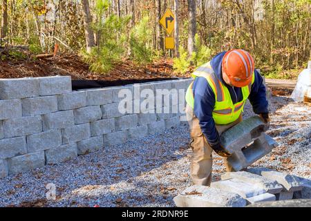 Bauarbeiter arbeiten derzeit an der Wandbefestigung, während sie die Wandbefestigung auf dem neuen Grundstück errichten. Stockfoto