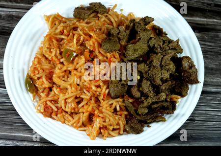 Klassische Spaghetti-Nudelmakkaroni mit Tomatensoße, Knoblauch, Zwiebeln, Gewürzen, Öl und schwarzem Pfeffer, Spaghetti ist eine lange, dünne, feste, zylindrische Pasta A. Stockfoto