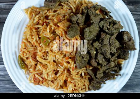 Klassische Spaghetti-Nudelmakkaroni mit Tomatensoße, Knoblauch, Zwiebeln, Gewürzen, Öl und schwarzem Pfeffer, Spaghetti ist eine lange, dünne, feste, zylindrische Pasta A. Stockfoto