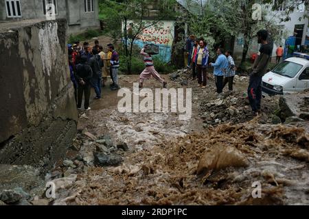 Srinagar, Kaschmir. 22. Juli 2023 22. Juli 2023, Srinagar Kaschmir, Indien : Ein Mann Springt nach Überschwemmungen im Gebiet Faqir Gujri am Stadtrand von Srinagar über das Hochwasser. Die Einheimischen behaupteten, dass mehrere Häuser Risse entwickelten und Maisfelder beschädigt wurden, es wurden jedoch keine Todesfälle gemeldet. Mehrere Regionen von Jammu und Kaschmir sind von anhaltenden starken Regenfällen heimgesucht worden, die zu mehreren Erdrutschen in den hügeligen Gebieten geführt haben und zur Schließung des Nationalautobahn Jammu-Srinagar geführt haben. Kredit: Eyepix Group/Alamy Live News Stockfoto