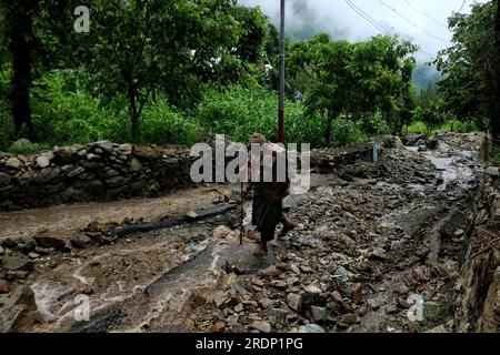 Srinagar, Kaschmir. 22. Juli 2023 22. Juli 2023, Srinagar Kaschmir, Indien : ein älterer Kaschmiri-Mann geht auf einer beschädigten hügeligen Straße nach Überschwemmungen in der Gegend von Faqir Gujri, am Stadtrand von Srinagar. Die Einheimischen behaupteten, dass mehrere Häuser Risse entwickelten und Maisfelder beschädigt wurden, es wurden jedoch keine Todesfälle gemeldet. Mehrere Regionen von Jammu und Kaschmir sind von anhaltenden starken Regenfällen heimgesucht worden, die zu mehreren Erdrutschen in den hügeligen Gebieten geführt haben und zur Schließung des Nationalautobahn Jammu-Srinagar geführt haben. Kredit: Eyepix Group/Alamy Live News Stockfoto