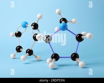 Nikotinmolekül auf hellblauem Hintergrund. Chemisches Modell Stockfoto