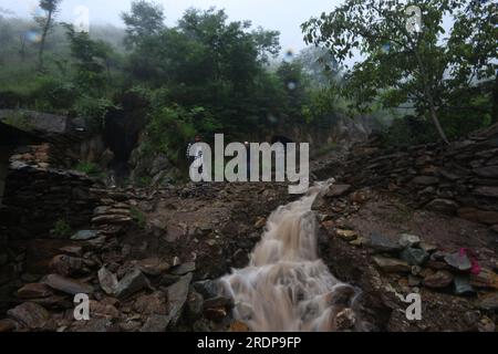 Srinagar, Kaschmir. 22. Juli 2023, Srinagar, Jammu und Kaschmir, Indien: Einheimische überqueren eine beschädigte Straße nach Überschwemmungen im Gebiet Faqir Gujri am Stadtrand von Srinagar, der Sommerhauptstadt des indischen Kaschmirs, am 22. Juli 2023. Die Einheimischen behaupteten, dass mehrere Häuser Risse entwickelten und Maisfelder beschädigt wurden, es wurden jedoch keine Todesfälle gemeldet. Mehrere Regionen von Jammu und Kaschmir sind von anhaltenden starken Regenfällen heimgesucht worden, die zu mehreren Erdrutschen in den hügeligen Gebieten geführt haben und zur Schließung des Nationalautobahn Jammu-Srinagar geführt haben. Kredit: ZUMA Press, Inc./Alamy Live News Stockfoto