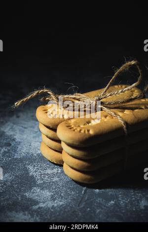 Kekse, die mit einem Seil auf abstraktem Hintergrund gebunden sind Stockfoto