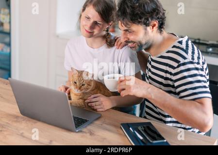 Glückliches Paar mit Katze zu Hause Stockfoto