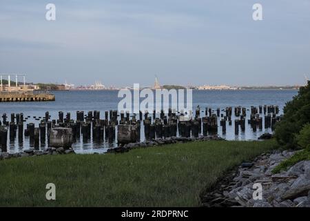 Blick auf die Freiheitsstatue vom Brooklyn Bridge Park, einem Park auf der Brooklyn-Seite des East River in New York City. Stockfoto