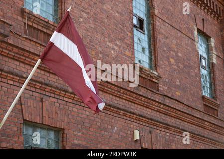 Die lettische Nationalflagge fliegt vor dem Karosta-Gefängnismuseum am ehemaligen russischen kaiserlichen und sowjetischen Marinestützpunkt an der Ostsee Stockfoto