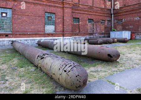 Alte heruntergekommene Torpedos oder Bomben liegen vor dem Karosta-Gefängnismuseum am ehemaligen russischen kaiserlichen und sowjetischen Marinestützpunkt an der Ostsee Stockfoto