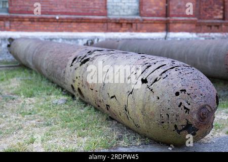 Alte heruntergekommene Torpedos oder Bomben liegen vor dem Karosta-Gefängnismuseum am ehemaligen russischen kaiserlichen und sowjetischen Marinestützpunkt an der Ostsee Stockfoto