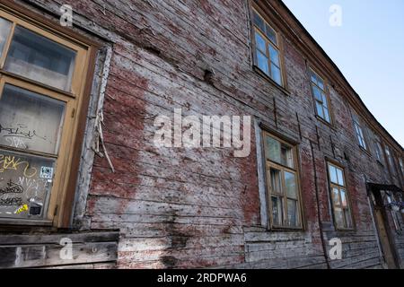 Fassade alter, malerloser und verfallener Holzhäuser in einer Straße in der Küstenstadt Pärnu in Estland Stockfoto