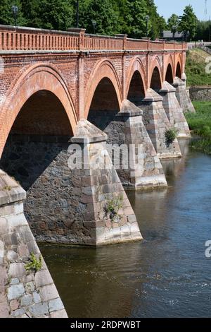 Die alte Backsteinbrücke auf der anderen Seite der Venta ist die längste Brücke dieser Art von Straßenbrücke in Europa. Kuldīga, Lettland Stockfoto