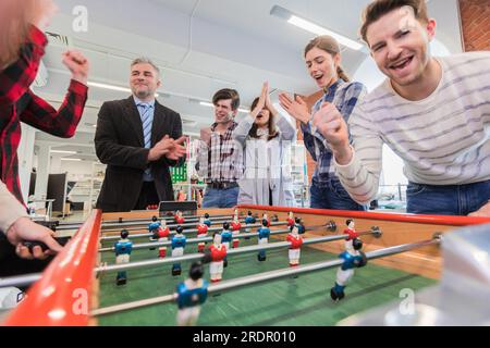 Mitarbeiter Spielen Table Soccer indoor Spiel im Büro während der Pausenzeit Stockfoto