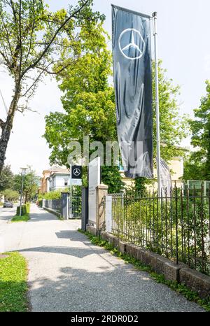 Villach, Österreich. Juli 18 2023. Eine Flagge mit dem Mercedes-Benz-Symbol über dem Eingang zu einem Autohändler im Stadtzentrum Stockfoto