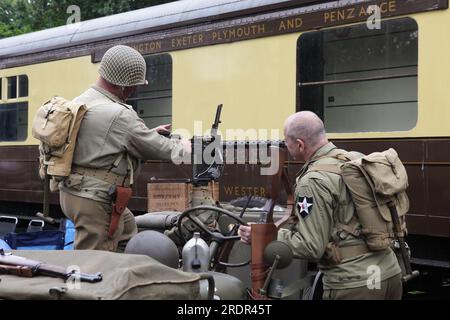 Zwei Enthusiasten in amerikanischer Militärkleidung sehen sich an, wie ein Maschinengewehr auf dem Heck ihres Jeeps während der Severn Valley Railway 1940er montiert wird Stockfoto