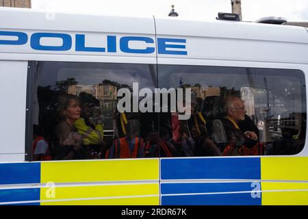 Hunderte von JSO-Demonstranten blockieren Straßen in Westminster und verursachen Verkehrsverzögerungen. Die Polizei wendet Gesetze nach dem Gesetz über öffentliche Ordnung an, um Demonstranten zu entfernen. Stockfoto