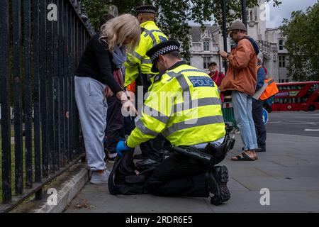 Hunderte von JSO-Demonstranten blockieren Straßen in Westminster und verursachen Verkehrsverzögerungen. Die Polizei wendet Gesetze nach dem Gesetz über öffentliche Ordnung an, um Demonstranten zu entfernen. Stockfoto