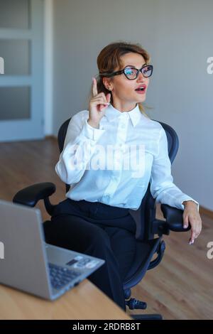 Geschäftsfrau, die eine Konferenz leitet. Weibliche Fachkraft, die ihren Kollegen eine Idee präsentiert. Teamdiskussion in einem modernen Büro. Stockfoto