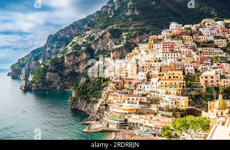 Naher Blick auf Positano, die Enklave in den Hügeln. Die majolica-geflieste Kuppel der Kirche Santa Maria Assunta unten rechts. Stockfoto