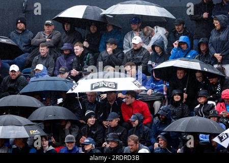Zuschauer schützen sich vor Regen am 4. Tag der Open im Royal Liverpool, Wirral. Foto: Sonntag, 23. Juli 2023. Stockfoto