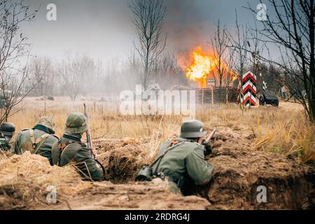 Nachbildungen, gekleidet als deutsche Wehrmacht-Infanterie-Soldaten, die in Trench defensiv kämpfen. Verteidigungsposition. Rauchschutz. Wird Aufgebaut Stockfoto