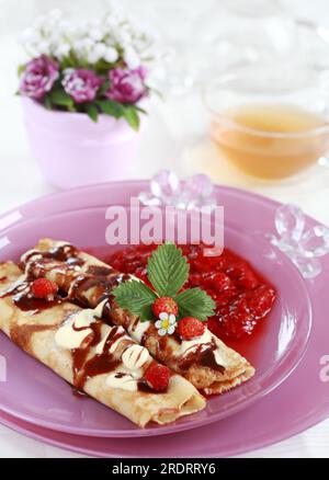 Köstliche Crepes mit Erdbeersauce und Schokolade Stockfoto