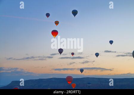 Das Foto wurde in der Türkei im Namen Kappadokiens aufgenommen. Das Bild zeigt den Flug von Ballons über ein Bergtal bei Sonnenaufgang. Stockfoto