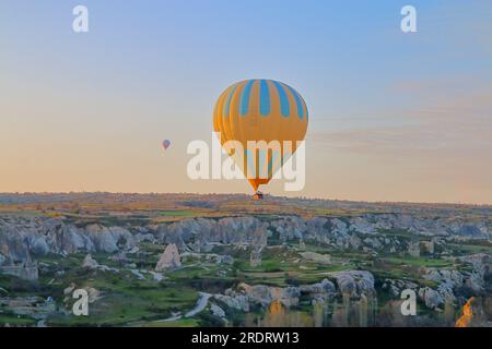 Das Foto wurde in der Türkei im Namen Kappadokiens aufgenommen. Das Bild zeigt den Flug von Ballons über ein Bergtal bei Sonnenaufgang. Stockfoto