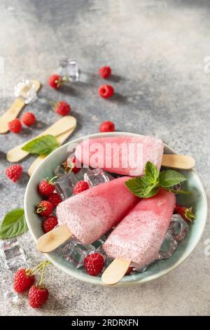 Eis. Sommerdessert. Hausgemachtes Himbeereis mit Joghurt und Himbeeren auf grauem Steinhintergrund. Speicherplatz kopieren. Stockfoto