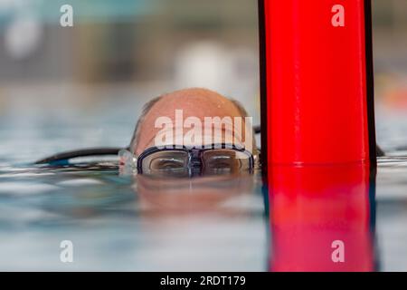 Subaqua-Taucher mit Schutzbrille an der Wasseroberfläche in einem Hallenbad, Großbritannien Stockfoto