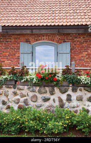 Vintage-Fenster und Balkon, dekoriert mit Geranium und anderen Blumen. Stockfoto