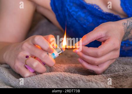 Ein wunderschönes braunes Model raucht Marihuana in der Privatsphäre ihres eigenen Zuhauses Stockfoto