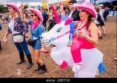 Henham Park, Suffolk, Großbritannien. 23. Juli 2023. Eine Gruppe von Freunden kleidet sich als Cowboys und bringt ein aufblasbares Einhorn mit, um Sophie Ellis-Bextor beim Spielen einer geheimen Akustik auf der kleinen Barclycard-Bühne im „Village“, dem Latitude Festival 2023, Henham Park, zuzusehen. Kredit: Guy Bell/Alamy Live News Stockfoto