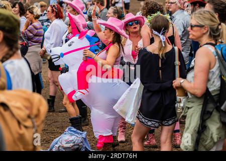 Henham Park, Suffolk, Großbritannien. 23. Juli 2023. Eine Gruppe von Freunden kleidet sich als Cowboys und bringt ein aufblasbares Einhorn mit, um Sophie Ellis-Bextor beim Spielen einer geheimen Akustik auf der kleinen Barclycard-Bühne im „Village“, dem Latitude Festival 2023, Henham Park, zuzusehen. Kredit: Guy Bell/Alamy Live News Stockfoto