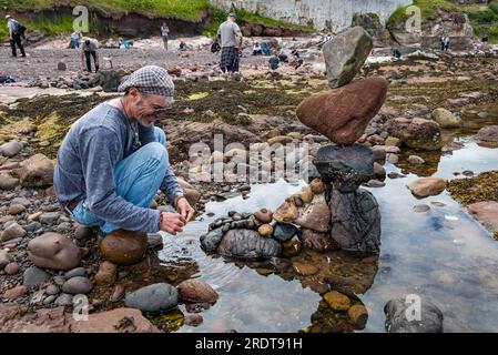 Charlie Jordan Balancing Stones on Beach, European Stone Stacking Championship und Land Art Festival, Dunbar, East Lothian, Schottland, Großbritannien Stockfoto