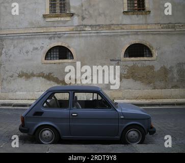 Landschaft mit malerischem Blick auf ein klassisches Fiat 126 Coupe, das auf dem Corso Vittorio Emanuele in Noto Sizilien, Italien, parkt. Stockfoto