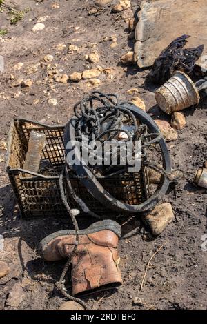 Alte Stiefel und anderer Müll wurden an einem Strand auf der Insel wight angespült. Gestrandeter Müll verschmutzt einen Strand in großbritannien. Stockfoto